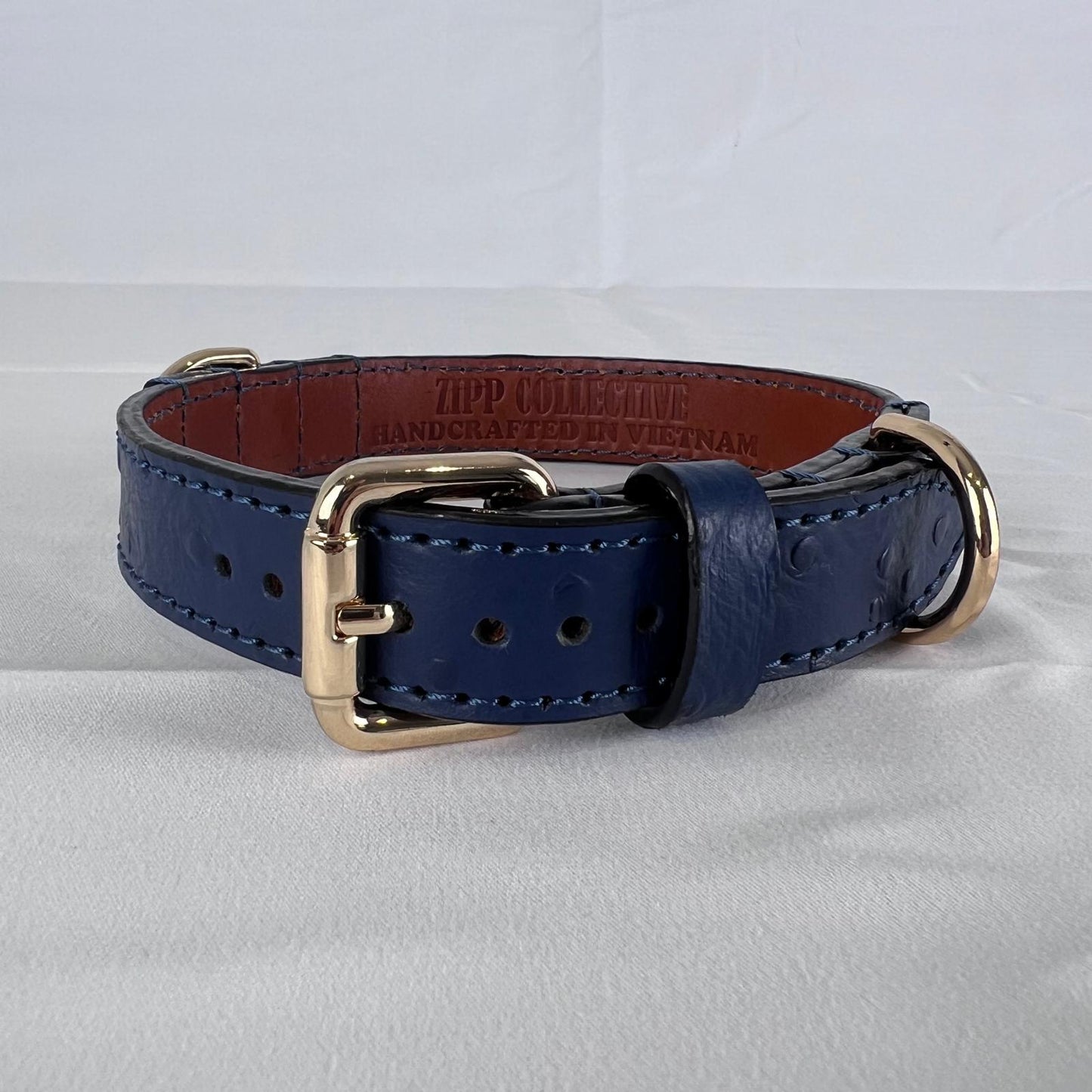 Navy blue leather dog collar with two gold-tone D-rings