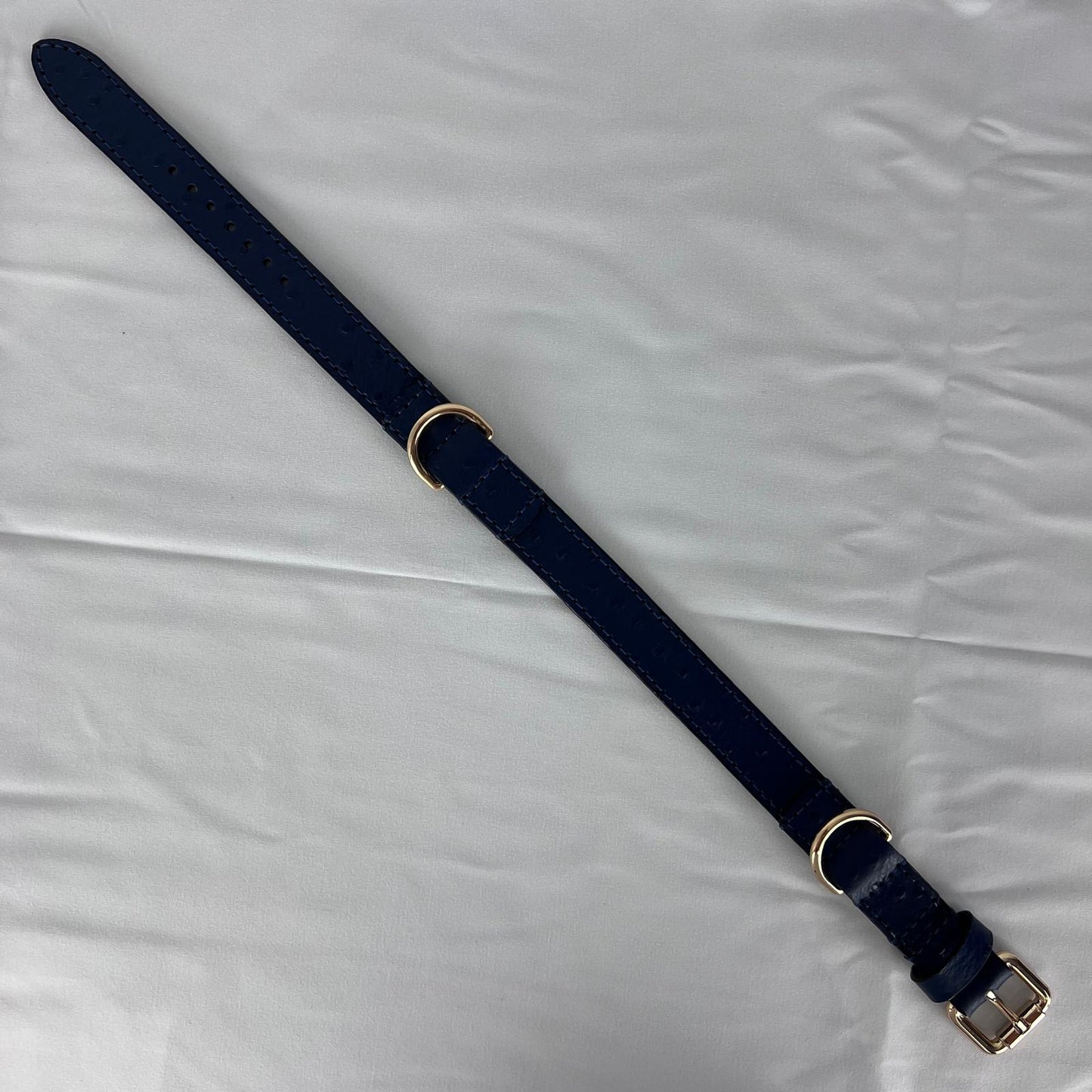 Full-length navy blue leather dog collars showing seven adjustment holes