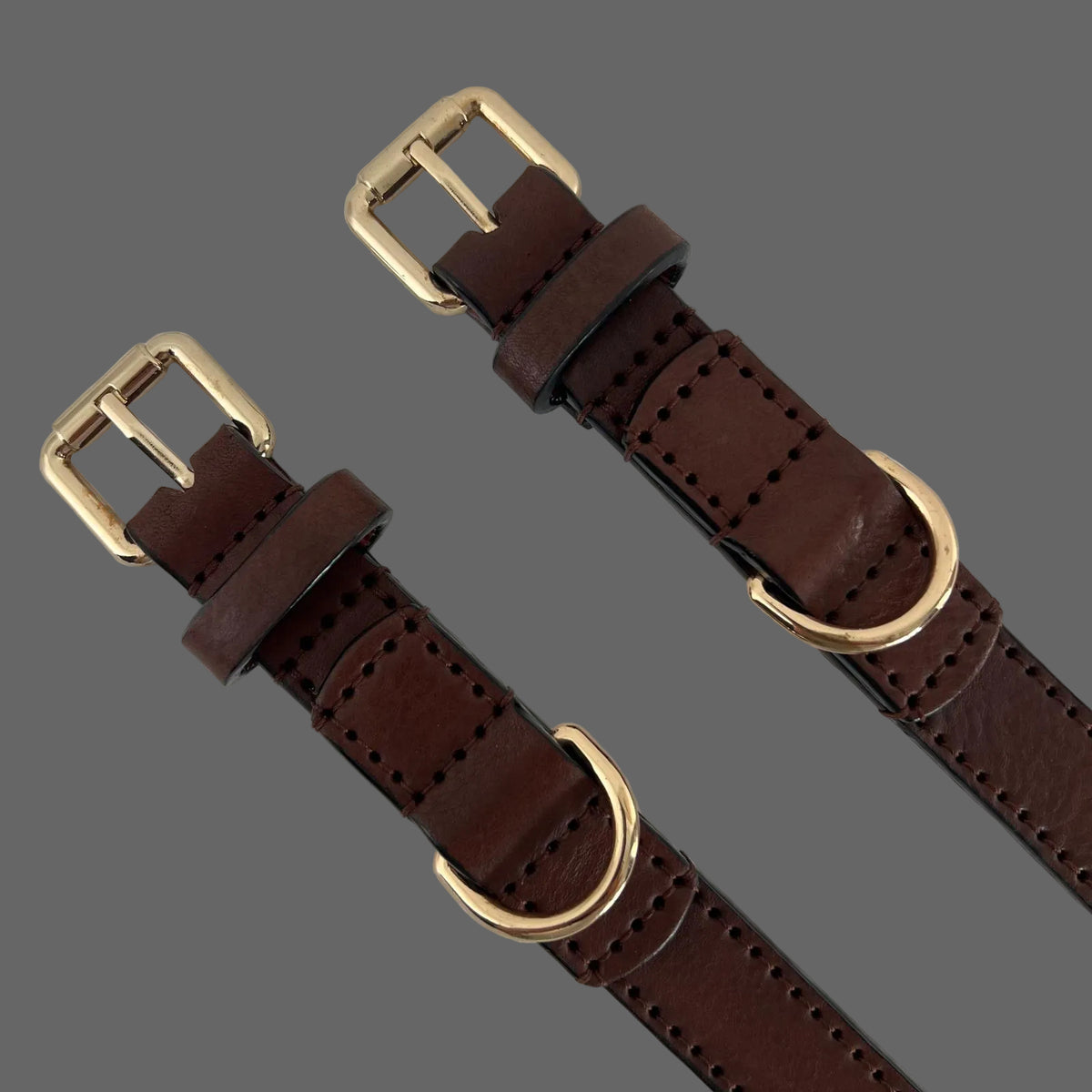 Close-up of gold-tone buckle and reinforced D-ring on a dark brown leather dog collar