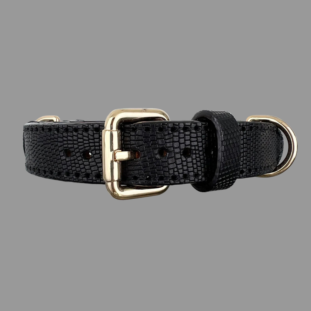 Close front view of a black lizard-embossed cowhide dog collar showing its gold-tone buckle, adjustment holes and leather keeper.