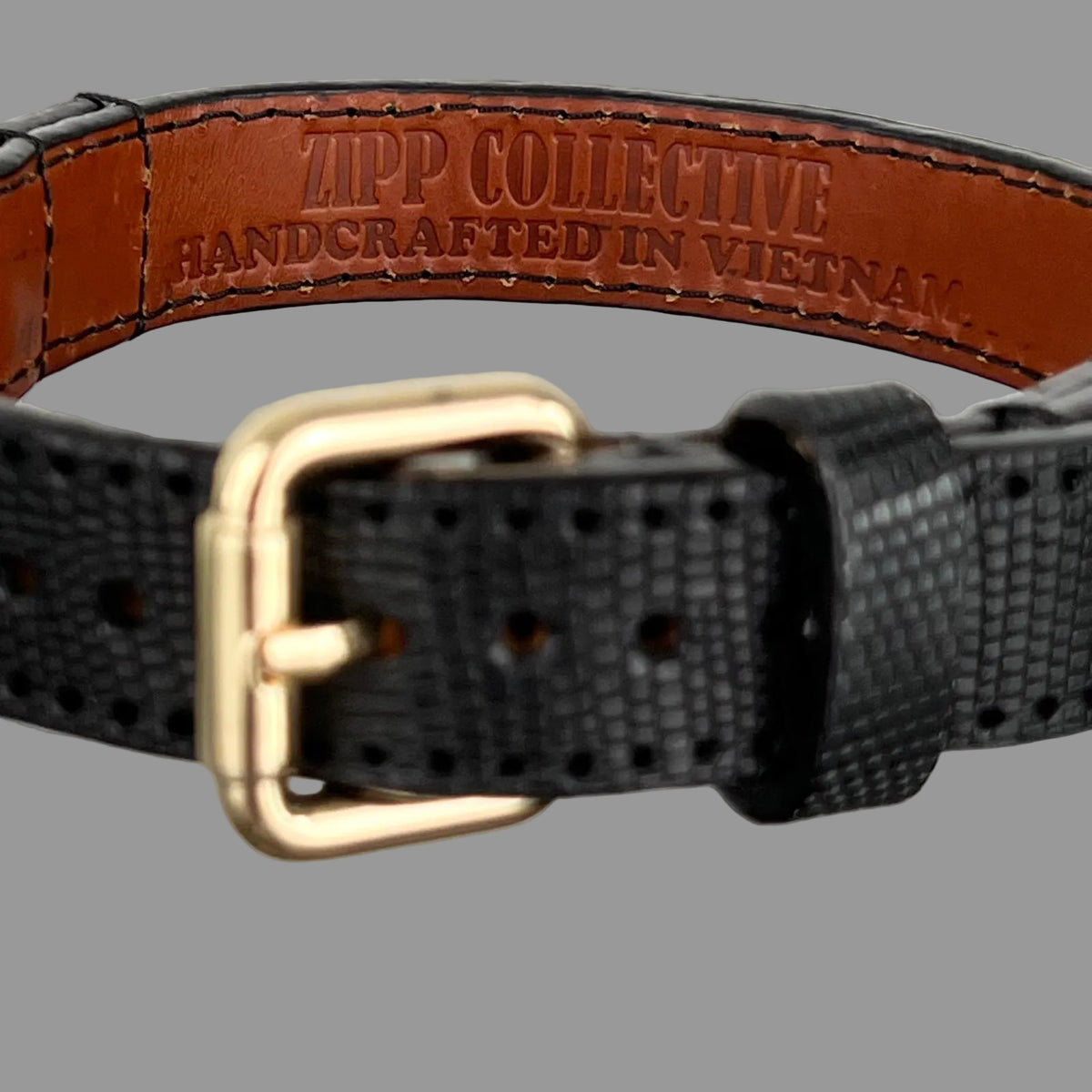 Brown leather lining stamped "ZIPP COLLECTIVE — HANDCRAFTED IN VIETNAM", with black stitching and finished edges.