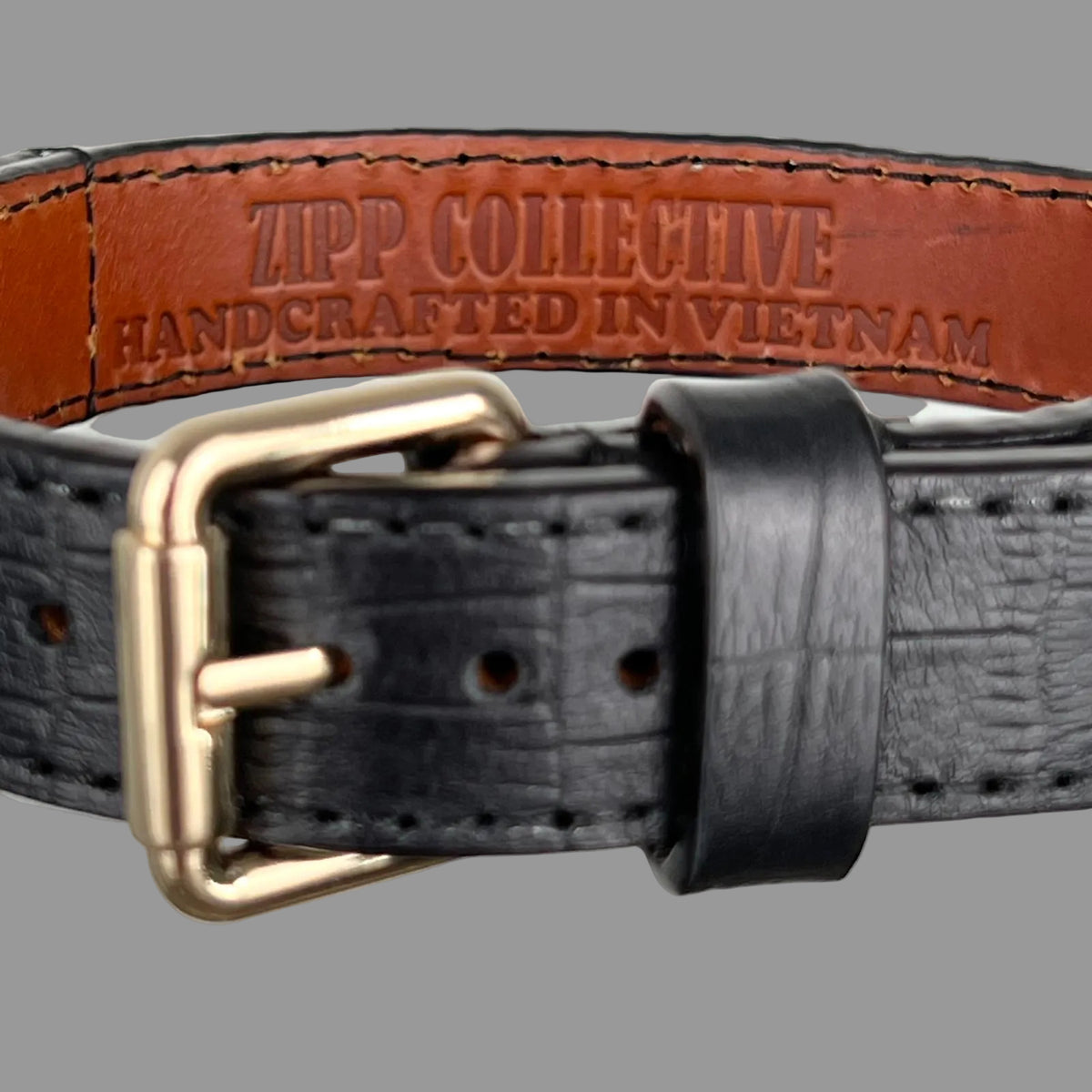 Brown leather lining stamped ZIPP COLLECTIVE — HANDCRAFTED IN VIETNAM inside a black embossed dog collar.