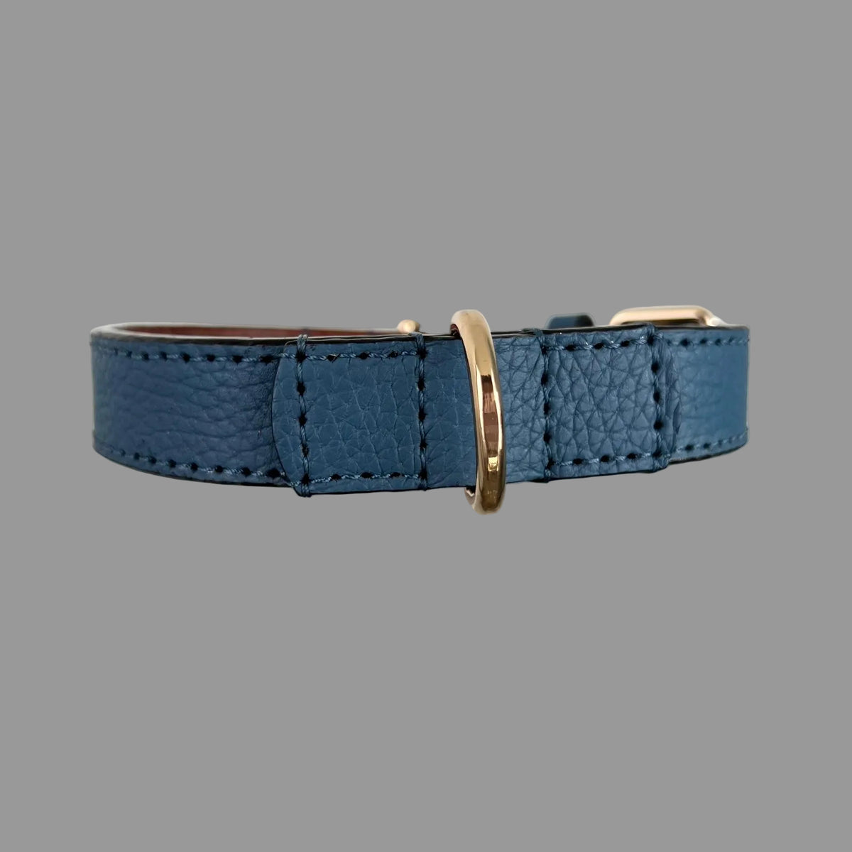 Gold-tone D-ring secured with reinforced blue pebbled leather and hand-stitching on a ZIPP COLLECTIVE dog collar.