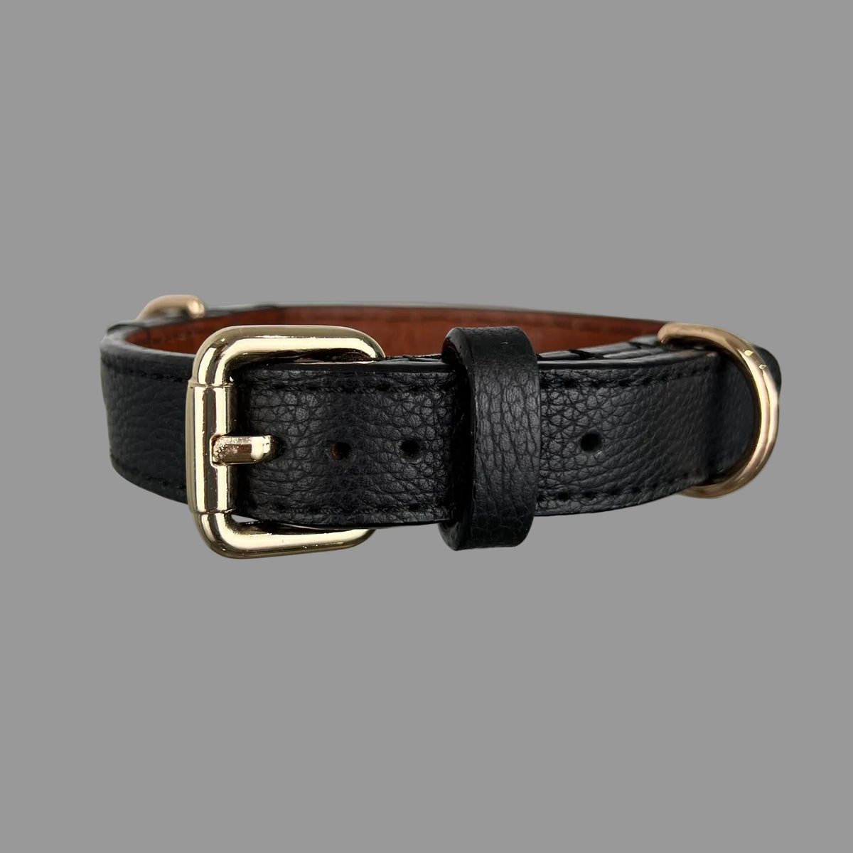 Front view of a black pebbled leather dog collar with gold-tone hardware and brown leather lining visible inside.