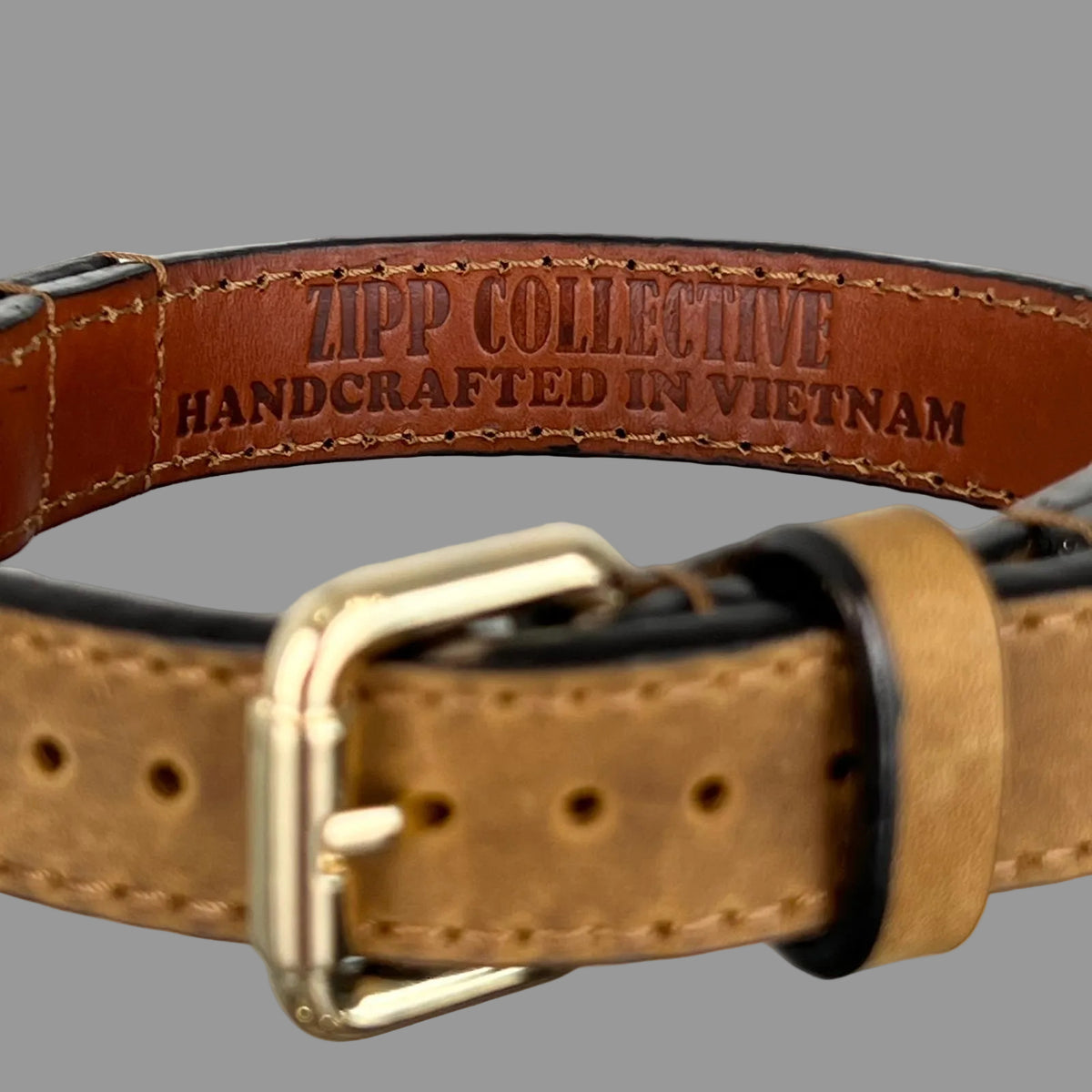 Brown leather lining stamped ZIPP COLLECTIVE — HANDCRAFTED IN VIETNAM inside a Vintage Brown dog collar.