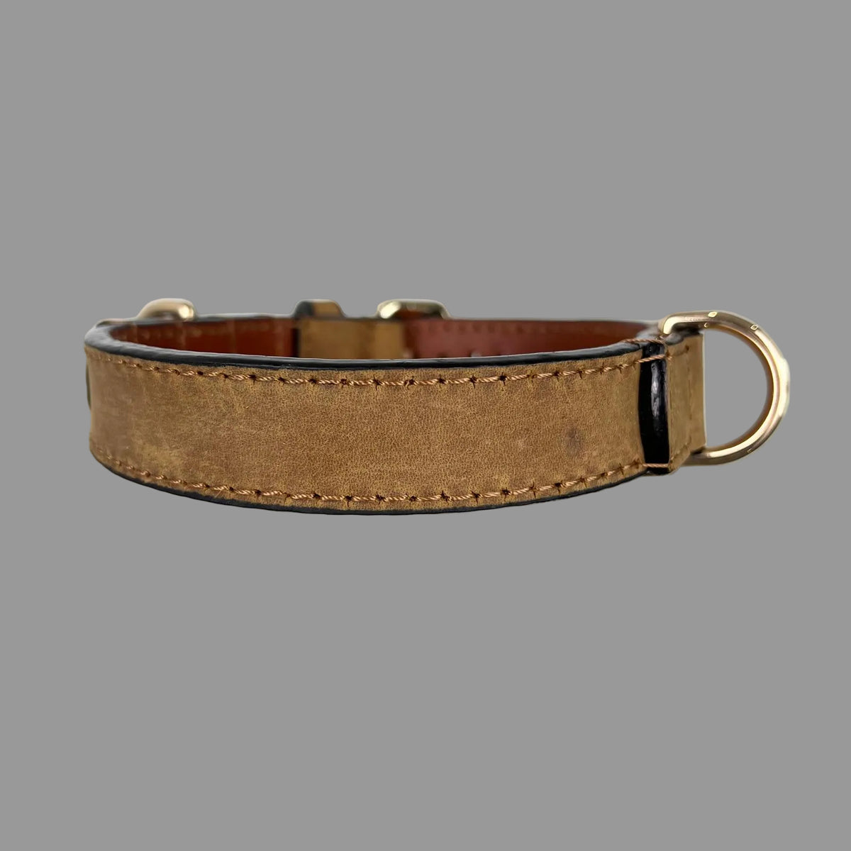 Brown cowhide dog collar showing its mottled surface, tonal stitching, dark finished edges and gold-tone D-ring.