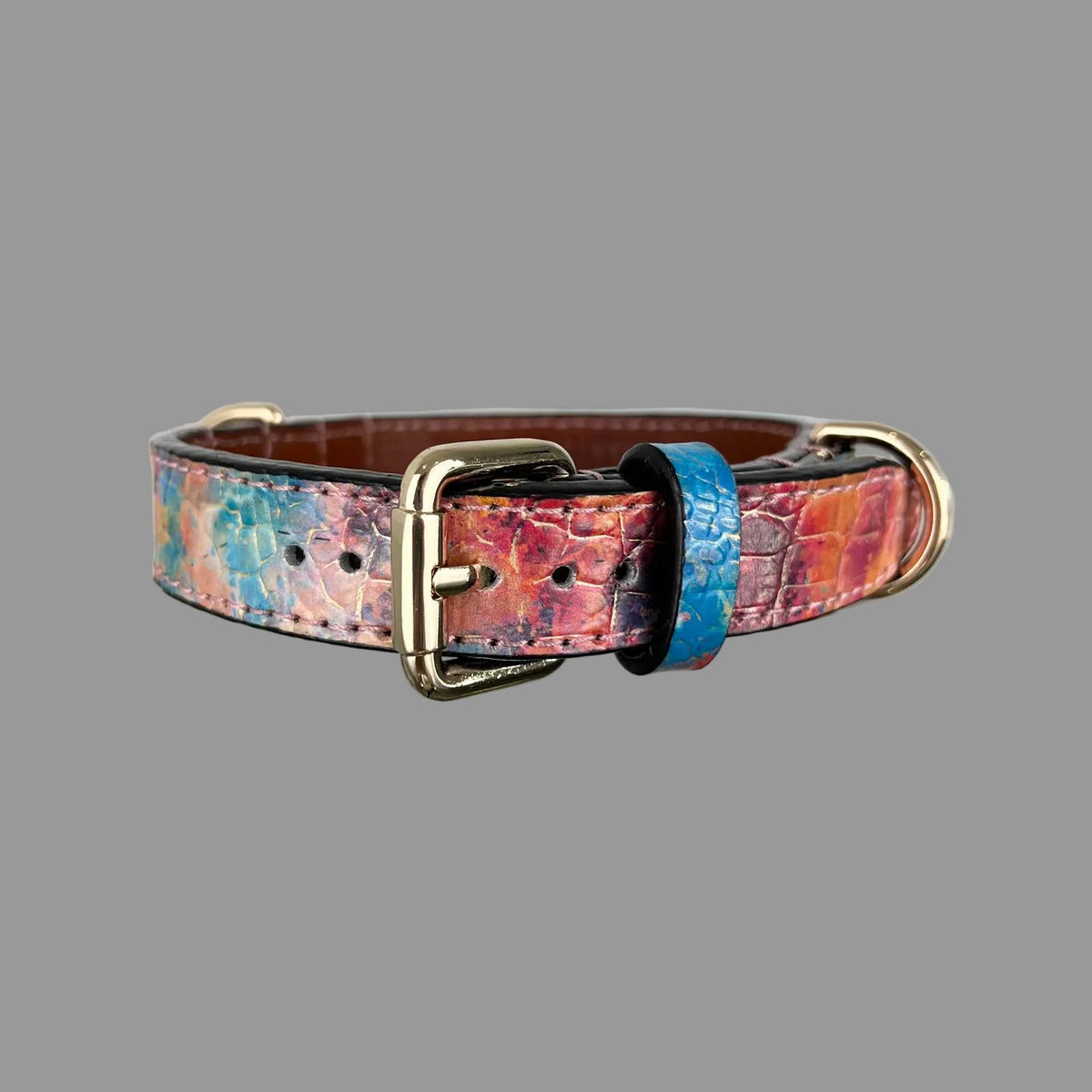 Angled front view of a multicolour croc-embossed leather dog collar with gold-tone hardware and brown lining.
