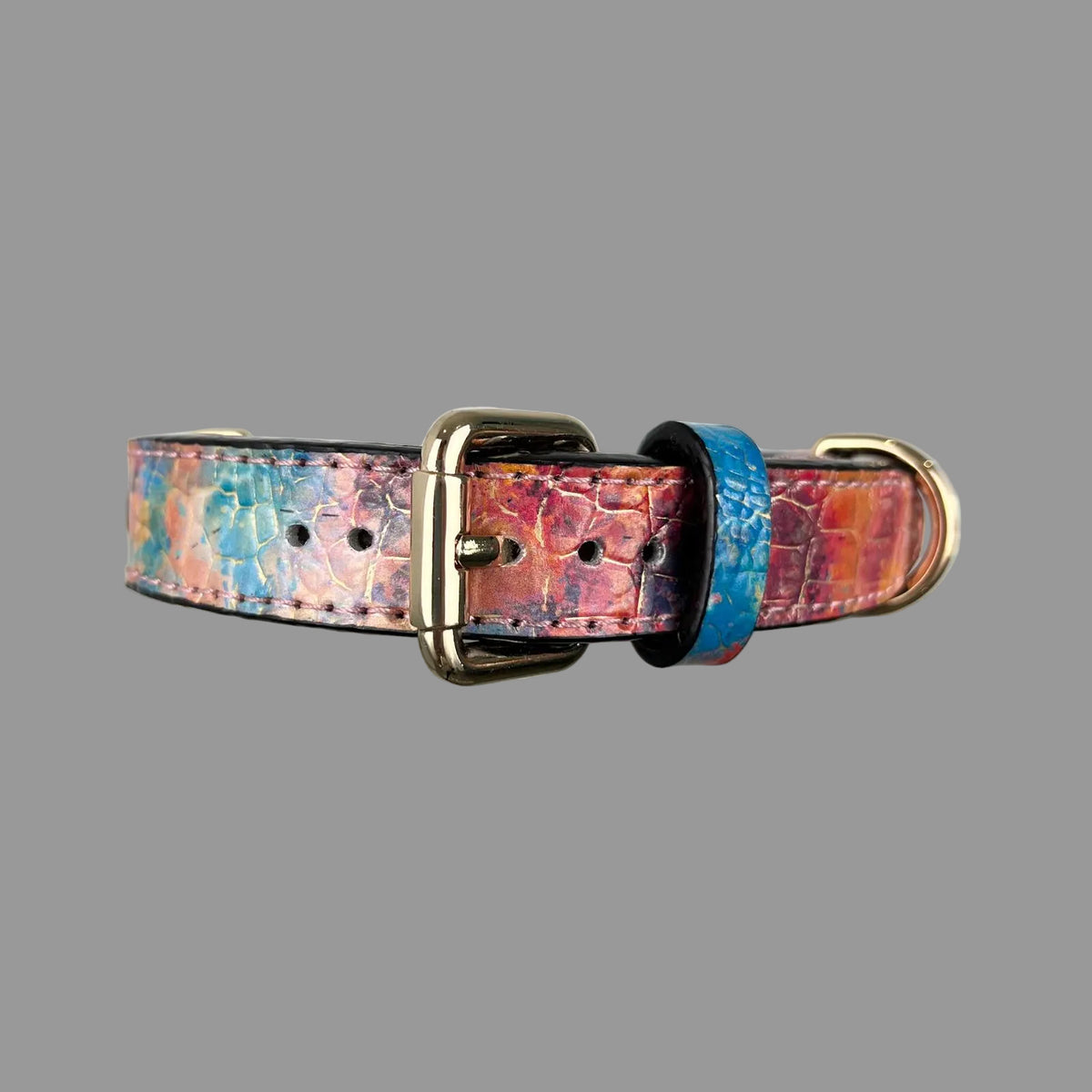 Multicolour croc-embossed dog collar with a gold-tone buckle, blue patterned keeper and adjustment holes.