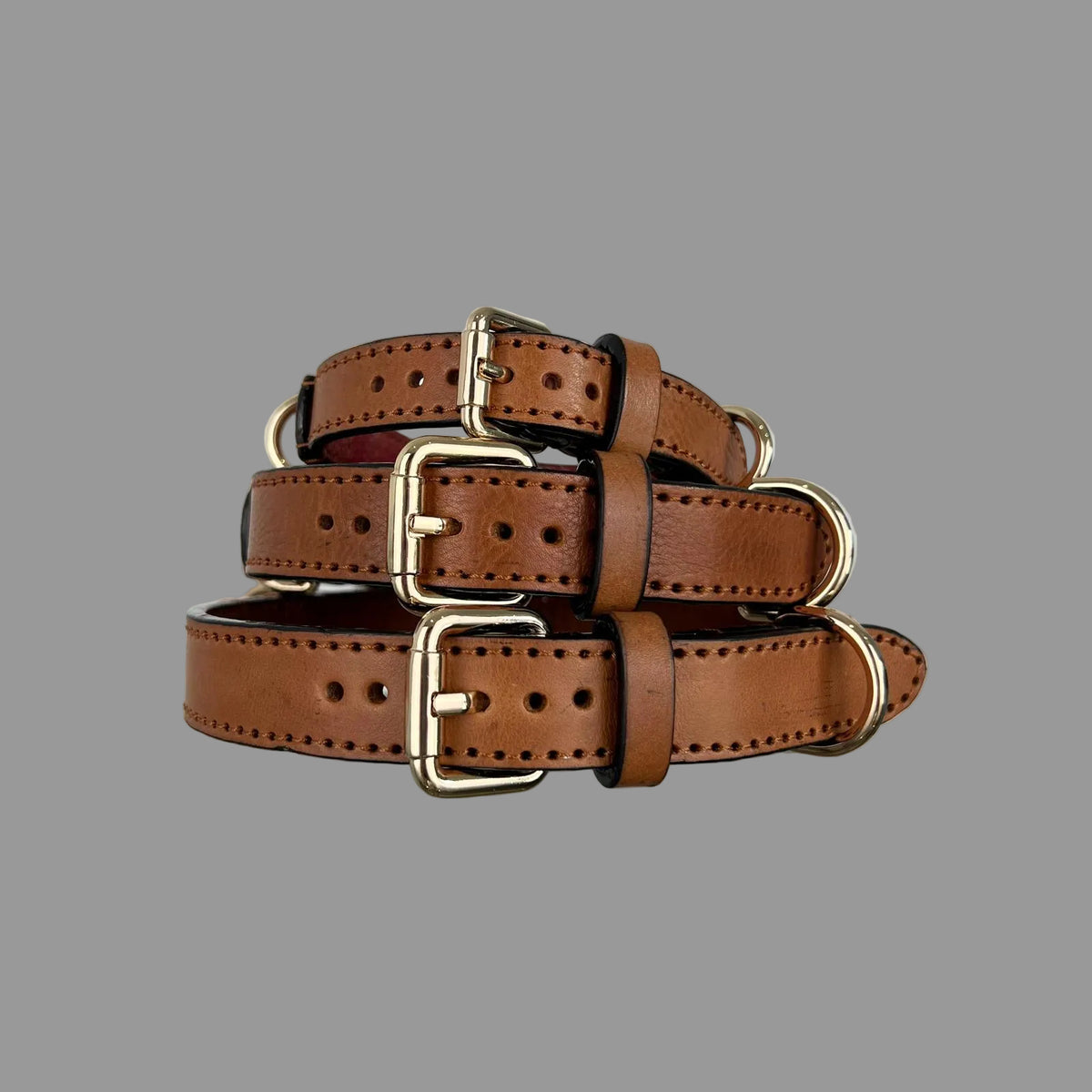 M, L and XL saddle brown collars showing cowhide grain, dark edges and red lining inside the M collar.