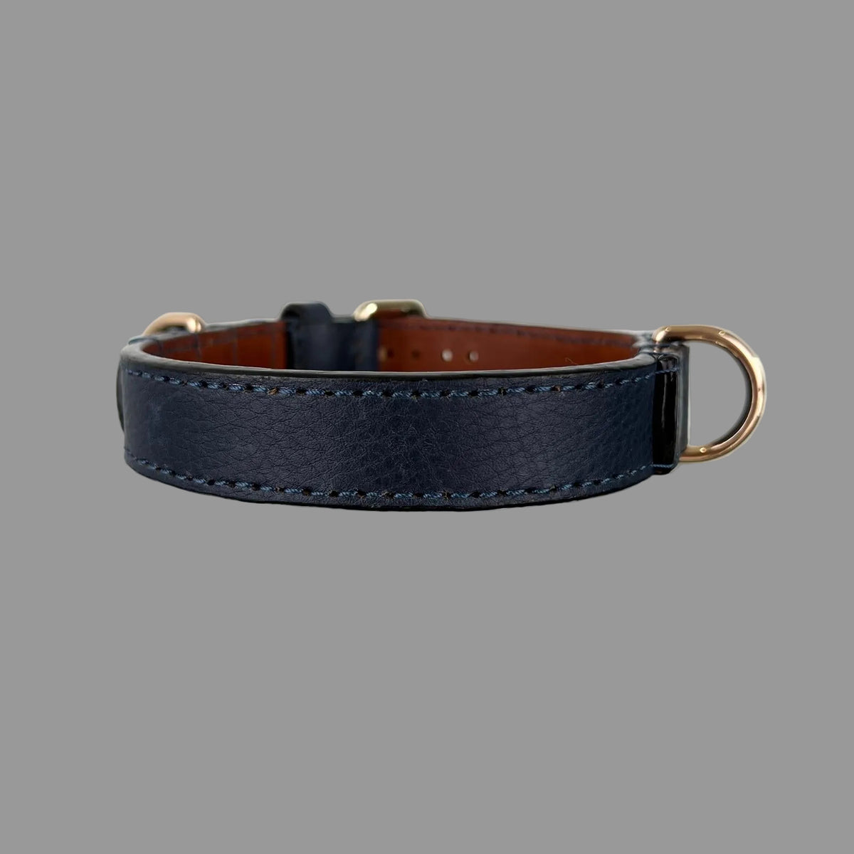 Navy blue leather dog collar with a gold-tone D-ring, stitched leather reinforcement and dark finished edges.
