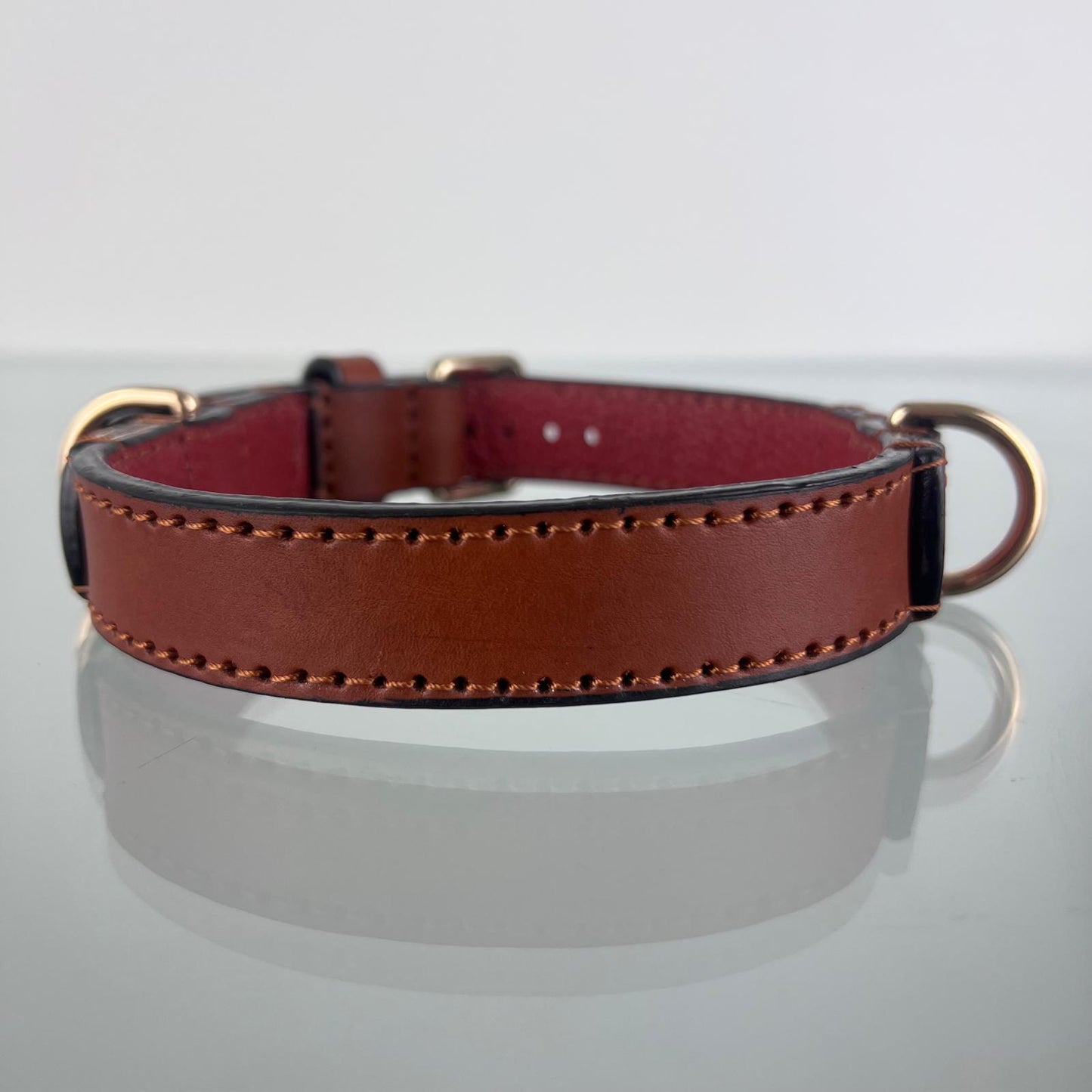 Rear view of a cognac brown leather dog collar showing hand stitching, black edges and two D-rings