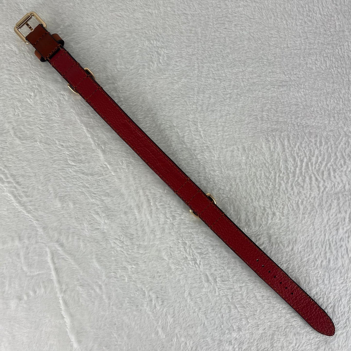 Full-length cognac brown dog collar showing red soft pebbled cowhide lining and seven adjustment holes